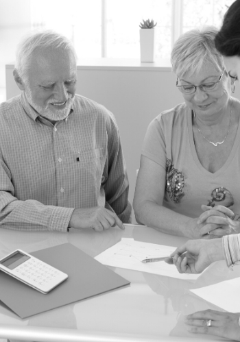 senior couple signing insurance paperwork