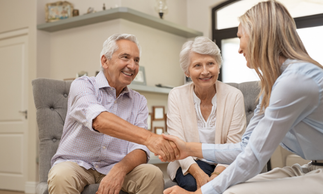 senior couple shaking hands with medicare insurance agent
